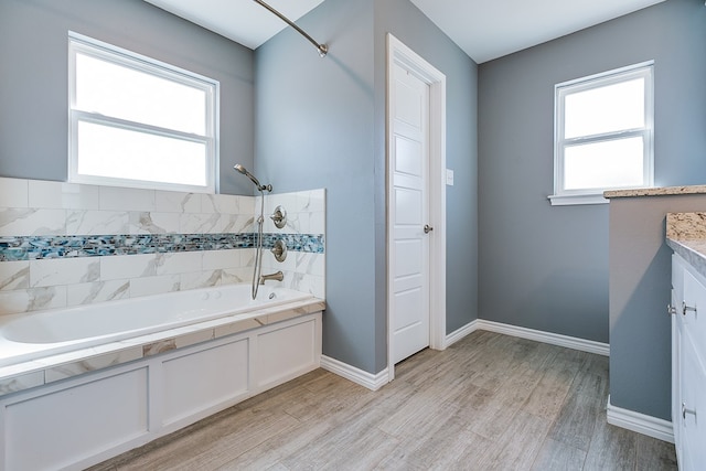 bathroom featuring wood-type flooring, a wealth of natural light, and vanity