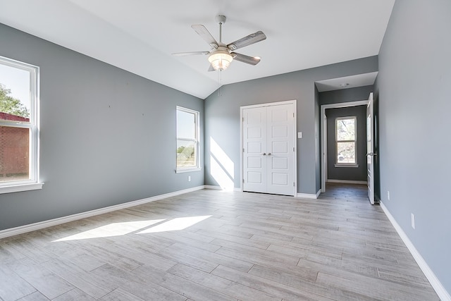 unfurnished bedroom featuring ceiling fan, multiple windows, and light hardwood / wood-style flooring