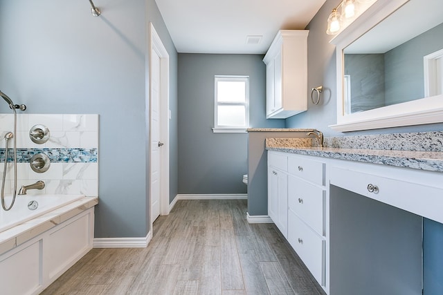 bathroom featuring wood-type flooring,  shower combination, and vanity