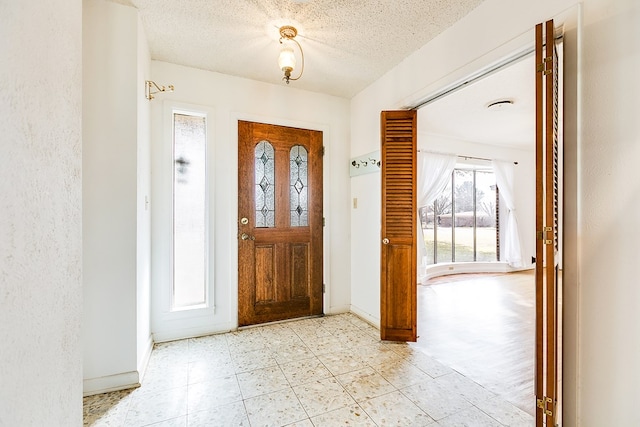 foyer entrance with a textured ceiling