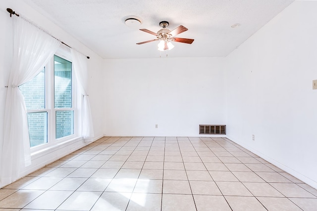 tiled spare room featuring ceiling fan and a textured ceiling