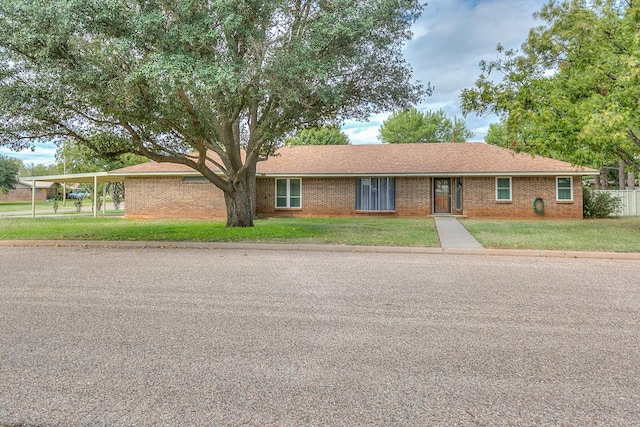 single story home featuring a carport and a front yard