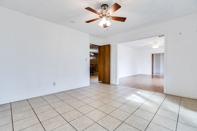 spare room with light tile patterned floors, a textured ceiling, and ceiling fan