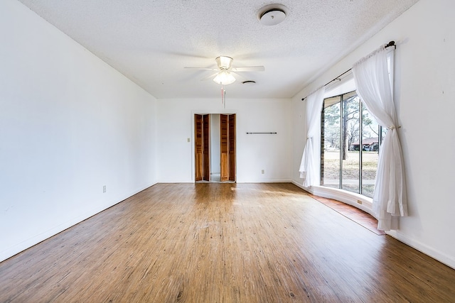 empty room featuring ceiling fan, a textured ceiling, and light hardwood / wood-style floors