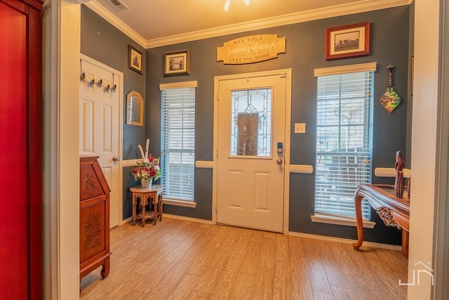foyer entrance with baseboards, ornamental molding, and light wood-style floors