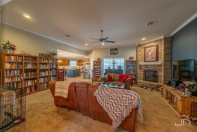 living room with carpet flooring, ornamental molding, a large fireplace, ceiling fan, and visible vents