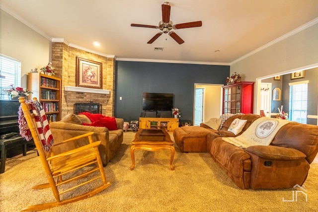 carpeted living area featuring a wealth of natural light, a fireplace, ceiling fan, and ornamental molding