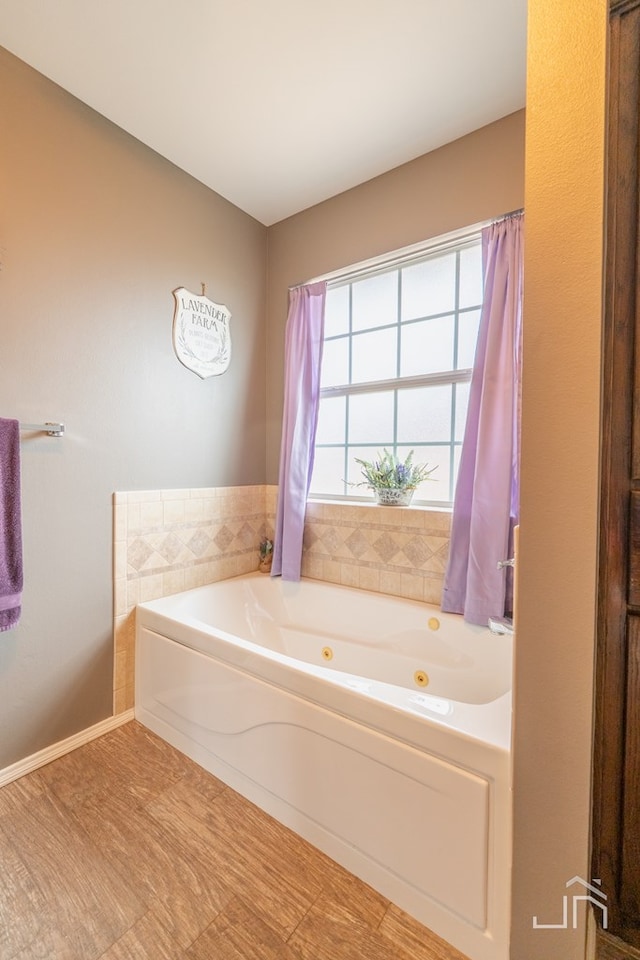 bathroom with baseboards and a whirlpool tub