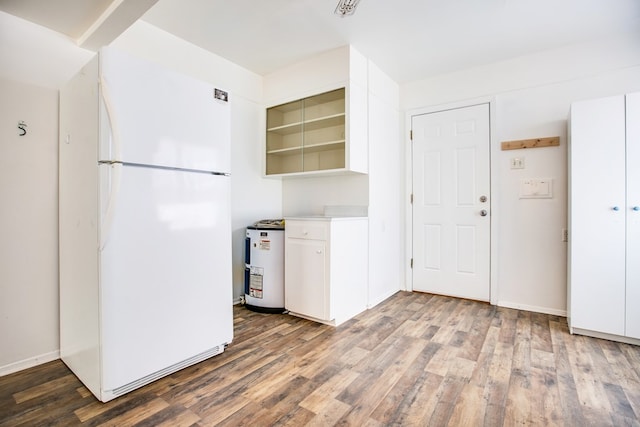 2609 W Harris Ave, San Angelo, TX 76901 - kitchen with freestanding refrigerator, wood finished floors, white cabinets, and light countertops