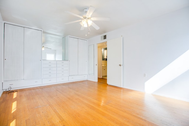 2609 W Harris Ave, San Angelo, TX 76901 - unfurnished bedroom featuring light wood-style flooring, two closets, and ceiling fan