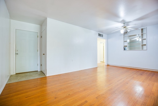 2609 W Harris Ave, San Angelo, TX 76901 - spare room featuring a ceiling fan, wood-type flooring, and built in shelves
