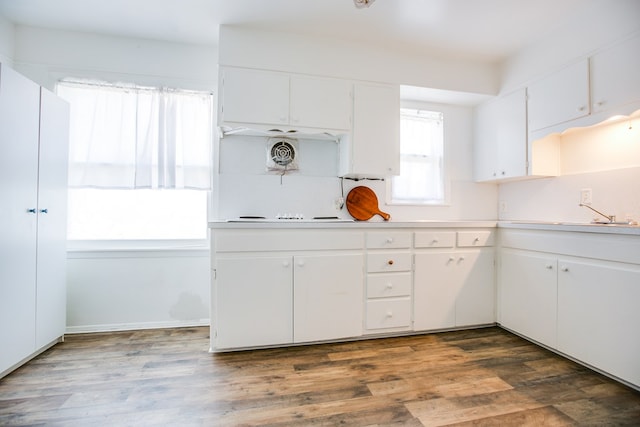 2609 W Harris Ave, San Angelo, TX 76901 - kitchen with light countertops, white cabinets, and wood finished floors