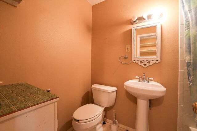 bathroom featuring a shower, sink, tile patterned floors, and toilet