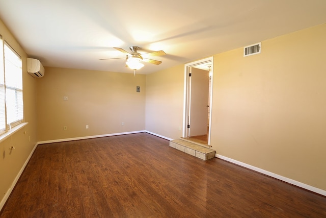 spare room featuring ceiling fan, dark hardwood / wood-style floors, and a wall unit AC