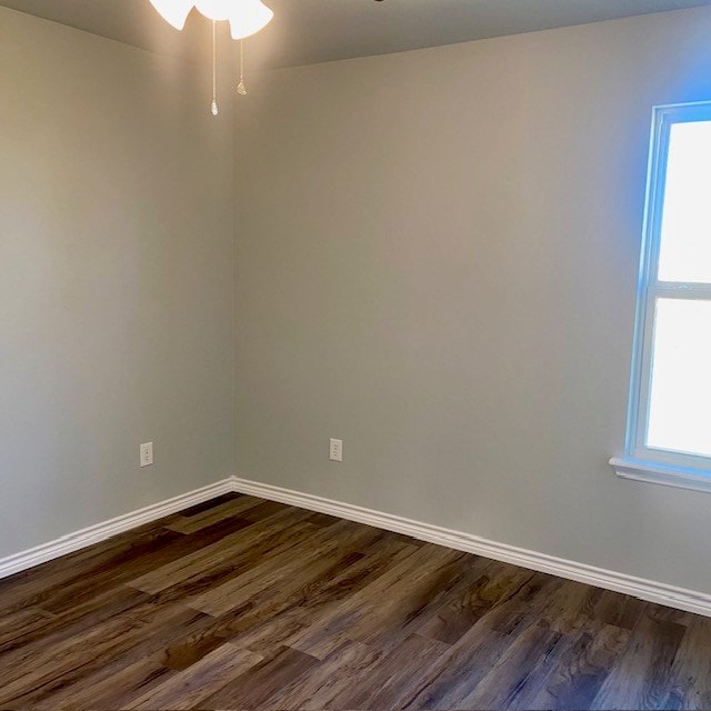 unfurnished room featuring ceiling fan, dark wood-style flooring, and baseboards