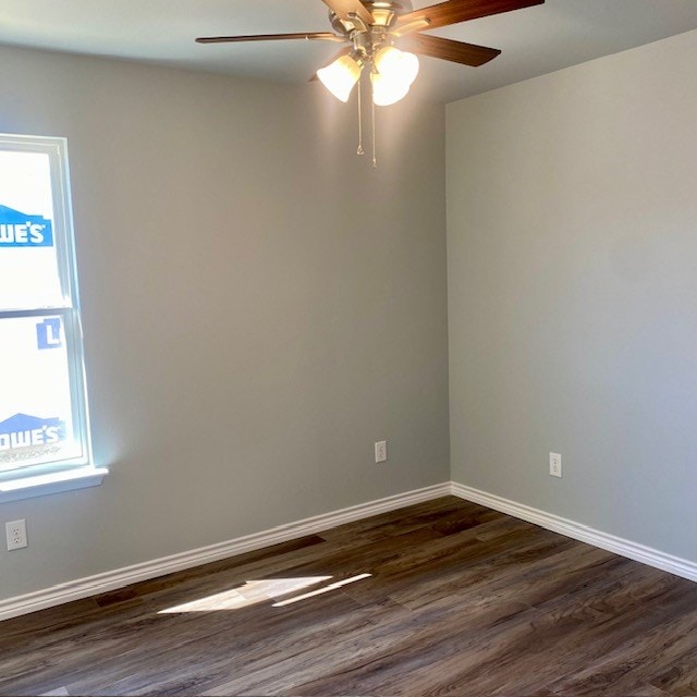 spare room with dark wood-style floors, ceiling fan, and baseboards