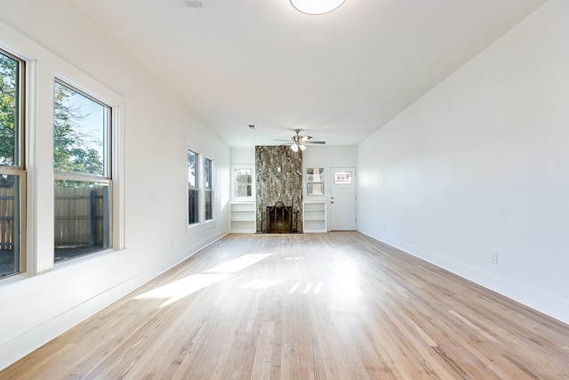 unfurnished living room featuring ceiling fan, light hardwood / wood-style floors, and a wealth of natural light