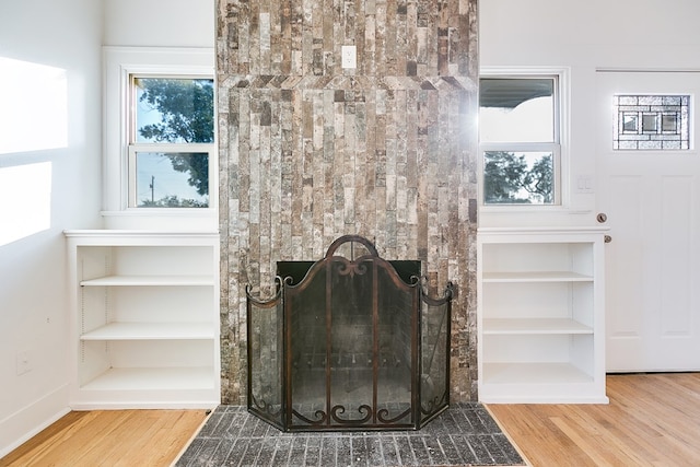 interior details with hardwood / wood-style flooring and a brick fireplace