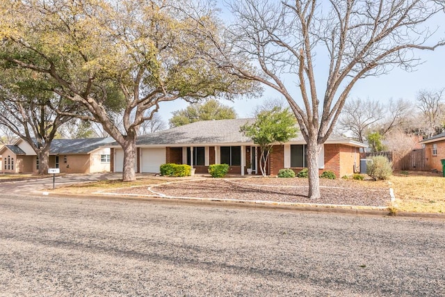 ranch-style house with brick siding, fence, and an attached garage