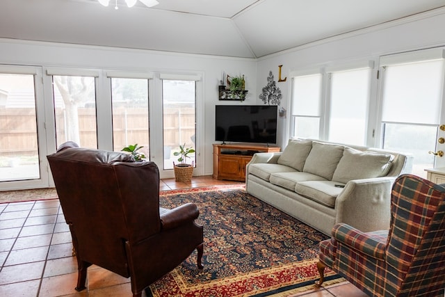 living area with light tile patterned floors, vaulted ceiling, and a wealth of natural light