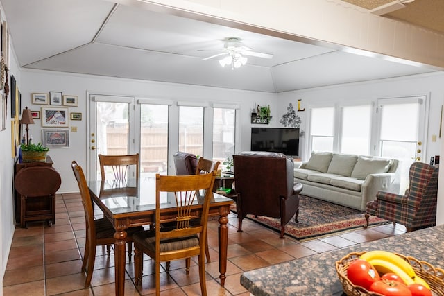 tiled dining space featuring lofted ceiling and ceiling fan