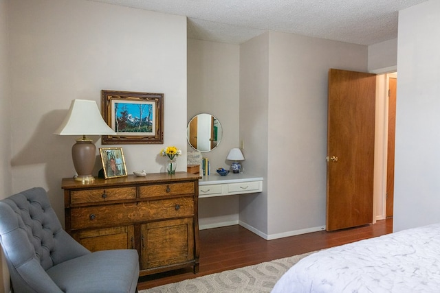 bedroom featuring a textured ceiling, dark wood-type flooring, and baseboards