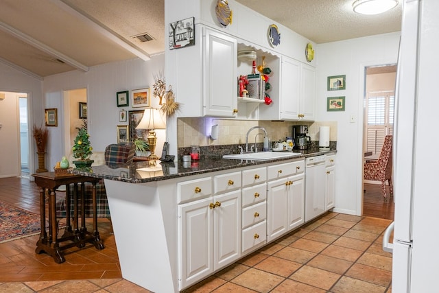 kitchen featuring tasteful backsplash, white cabinets, a sink, a textured ceiling, and white appliances