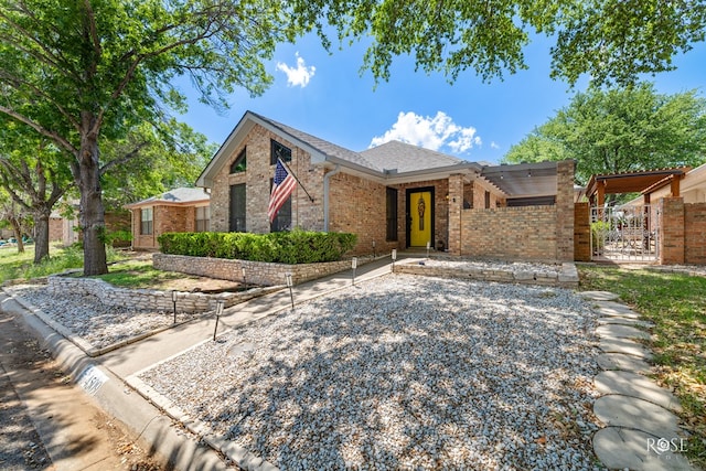 ranch-style home featuring a gate, fence, and brick siding