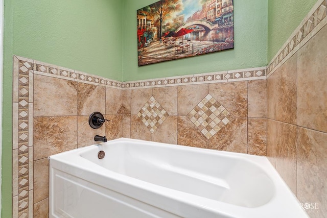 bathroom featuring a garden tub and a textured wall