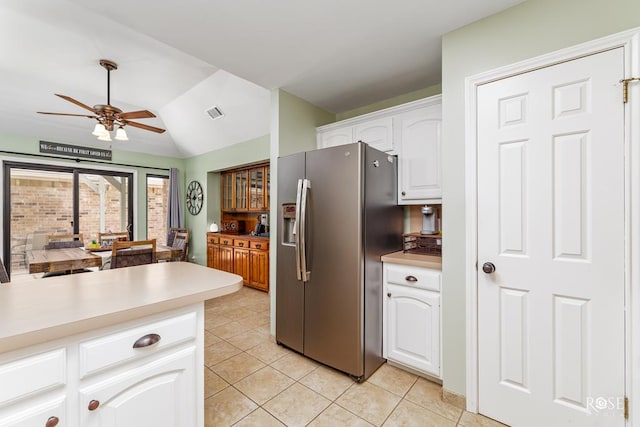 kitchen with a ceiling fan, stainless steel refrigerator with ice dispenser, light countertops, vaulted ceiling, and light tile patterned flooring