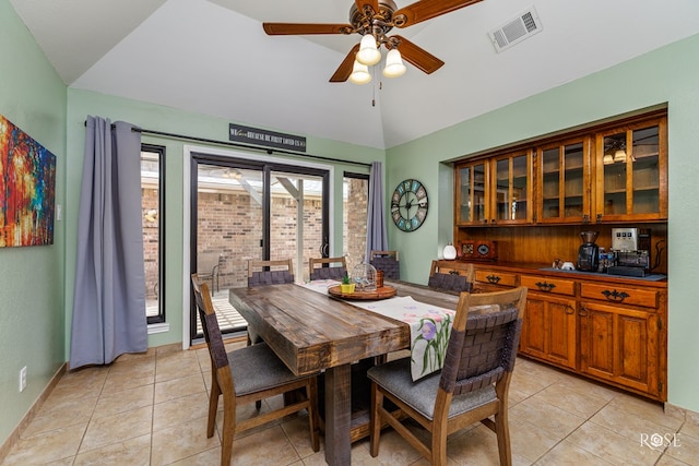 dining area featuring light tile patterned flooring, visible vents, lofted ceiling, and ceiling fan