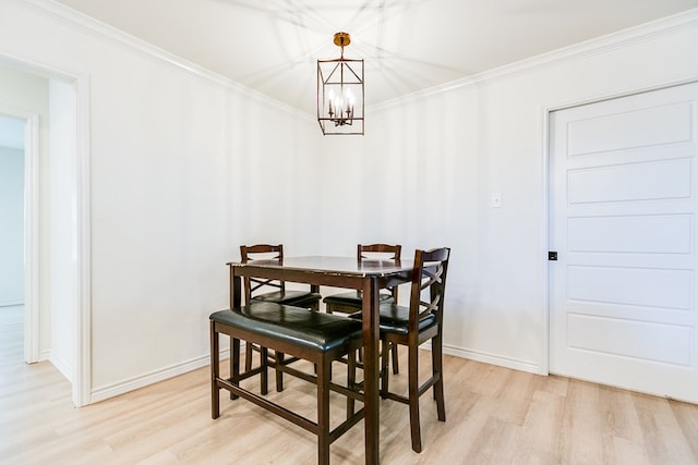 dining room featuring ornamental molding, a chandelier, and light hardwood / wood-style floors