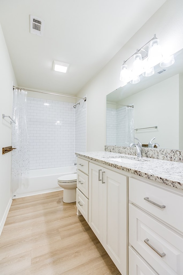 full bathroom with vanity, shower / tub combo, wood-type flooring, and toilet