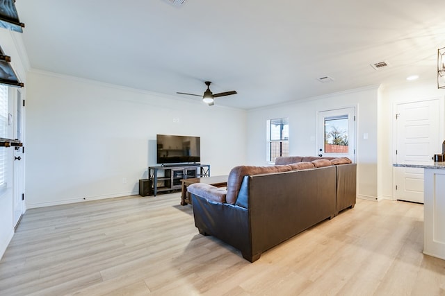 living room featuring crown molding, ceiling fan, and light hardwood / wood-style flooring