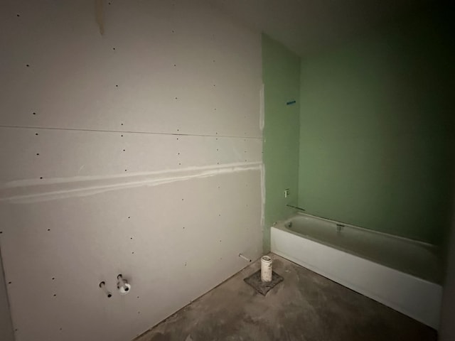 bathroom with a bath and concrete floors