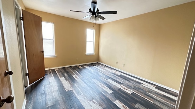 empty room with ceiling fan and dark hardwood / wood-style flooring