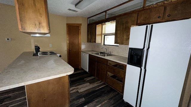 kitchen with sink, white appliances, dark wood-type flooring, tasteful backsplash, and kitchen peninsula