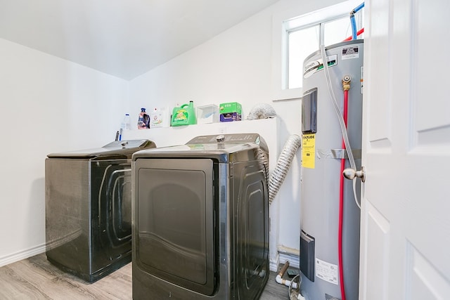 washroom featuring washer and dryer, light hardwood / wood-style floors, and water heater