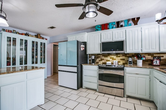 3118 Grandview Dr, San Angelo, TX 76904 - kitchen with appliances with stainless steel finishes, a ceiling fan, backsplash, white cabinets, and a textured ceiling