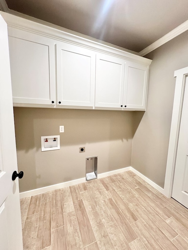 3962 Ruth Ln, San Angelo, TX 76904 - laundry area featuring electric dryer hookup, washer hookup, cabinet space, light wood-style floors, and crown molding