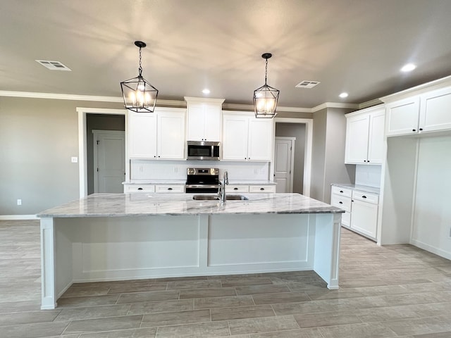 3962 Ruth Ln, San Angelo, TX 76904 - kitchen featuring stainless steel appliances, a sink, baseboards, ornamental molding, and a kitchen island with sink