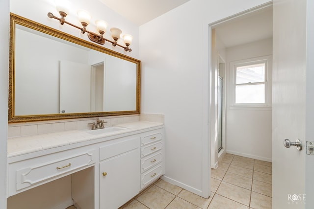 bathroom with a shower with shower door, tile patterned flooring, baseboards, and vanity