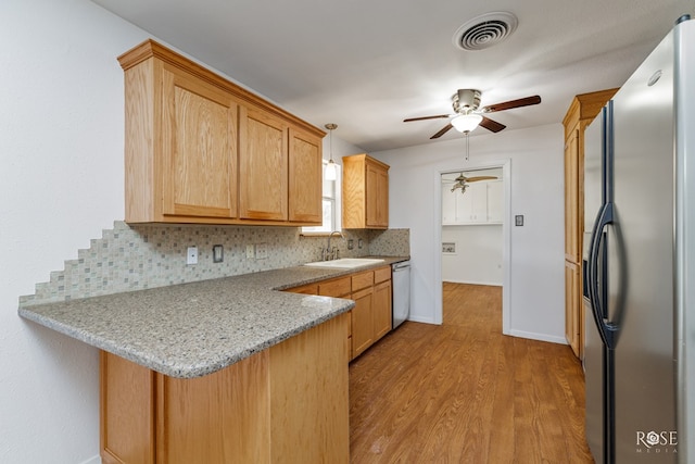 kitchen featuring ceiling fan, visible vents, a sink, a peninsula, and stainless steel appliances
