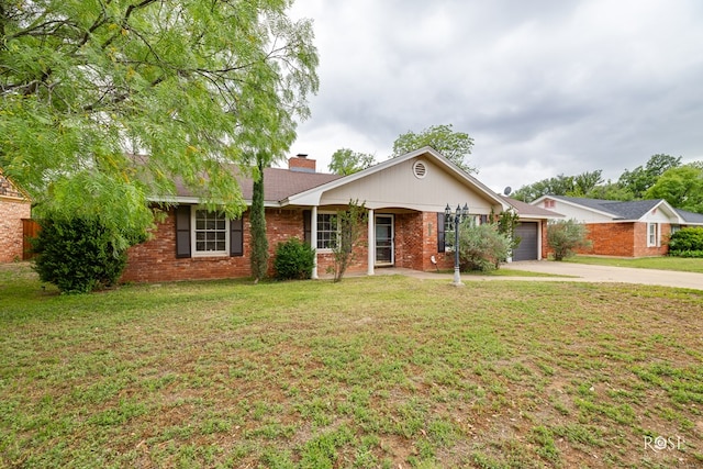 single story home featuring a chimney, brick siding, an attached garage, concrete driveway, and a front lawn