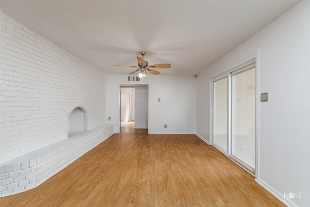 unfurnished living room with a brick fireplace, visible vents, baseboards, ceiling fan, and light wood-style floors