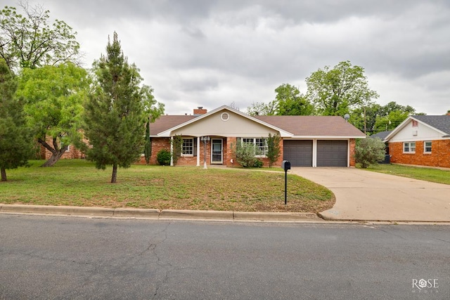 single story home featuring an attached garage, concrete driveway, brick siding, and a front lawn
