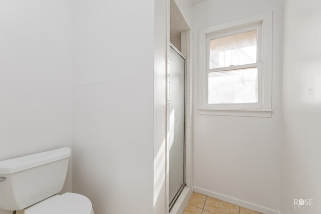 full bath featuring toilet, baseboards, tile patterned flooring, and a stall shower