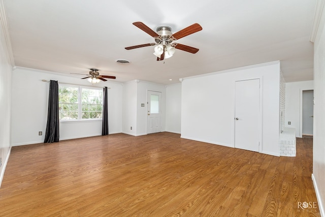 unfurnished living room with ceiling fan, light wood-style flooring, visible vents, and ornamental molding