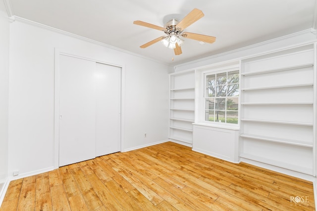 unfurnished bedroom featuring a closet, ornamental molding, ceiling fan, wood-type flooring, and baseboards