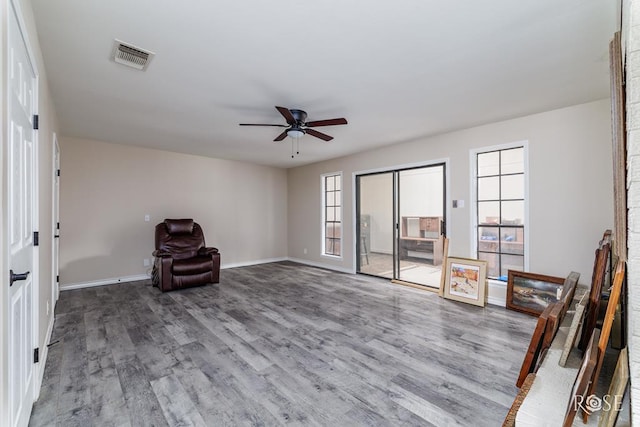 unfurnished room featuring baseboards, a ceiling fan, wood finished floors, and visible vents